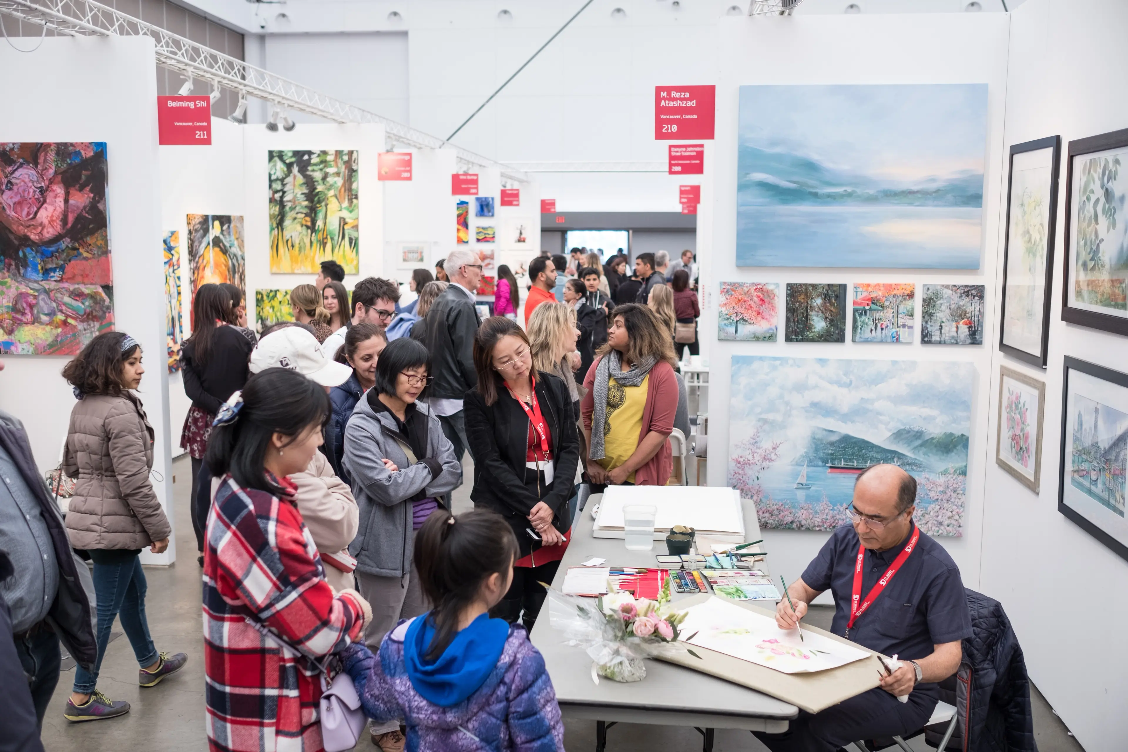 Attendees watch an artist in practice at Art Vancouver