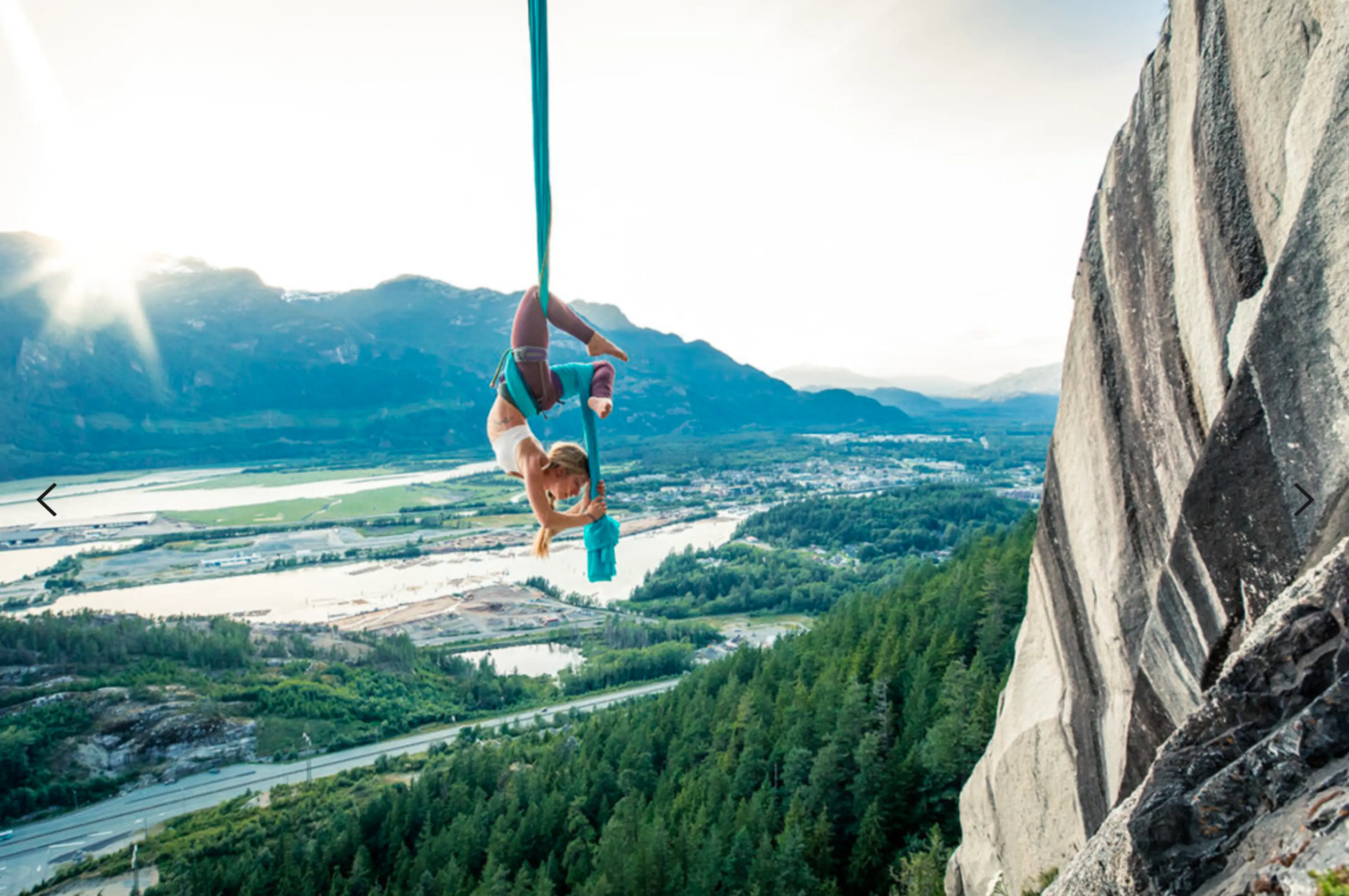 A woman suspended from aerial silks on the Stawamus Chief