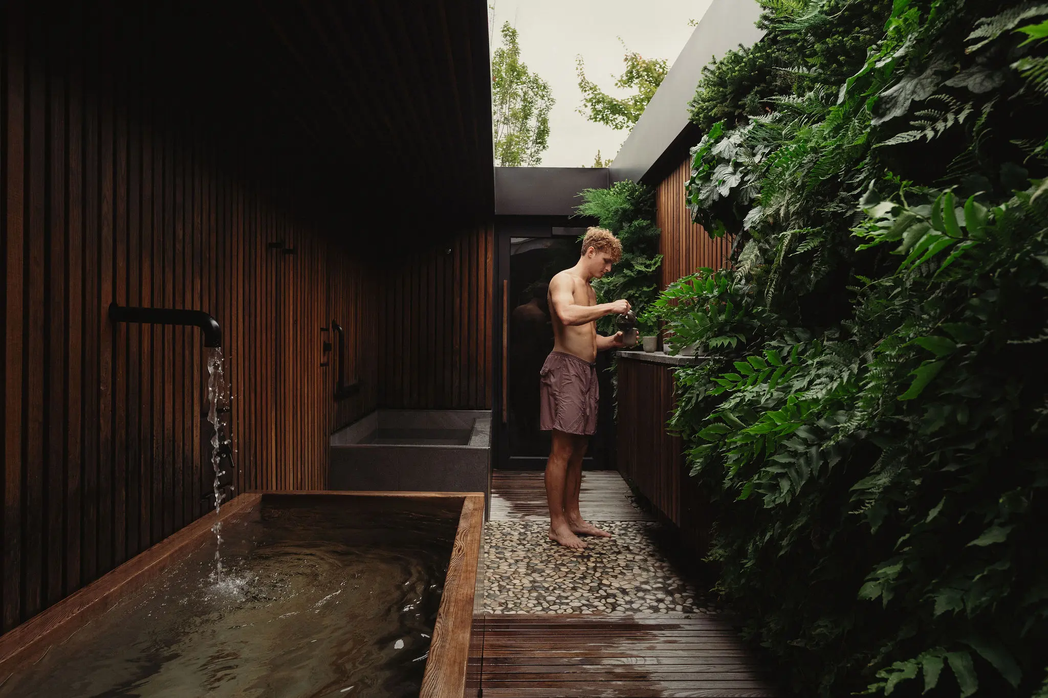 A man pouring in water into a glass at the Circle Wellness Spa on Granville Island in Vancouver.