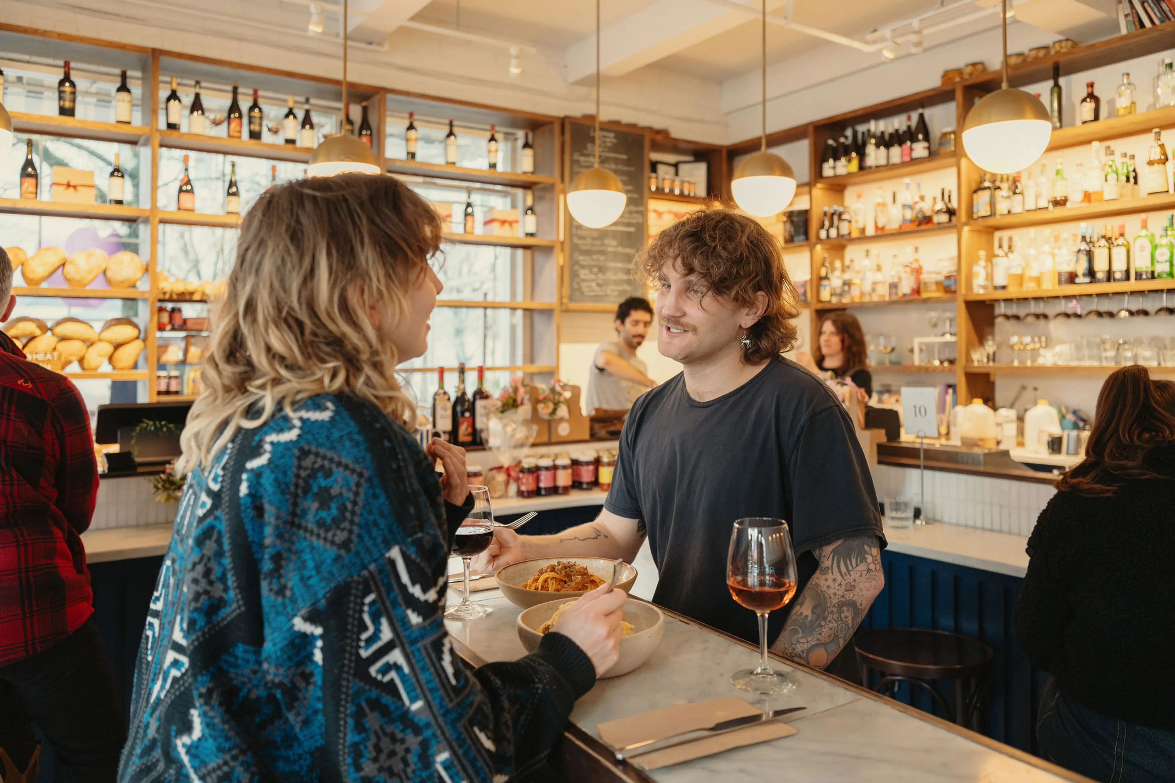 Two people sitting at a table drinking wine at LIVIA in Vancouver.