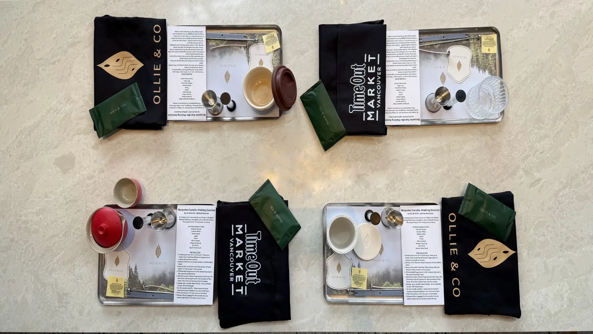 Four candle-making kits on a beige surface, each with a black cloth, green packet, metal tray, and candle-making supplies.