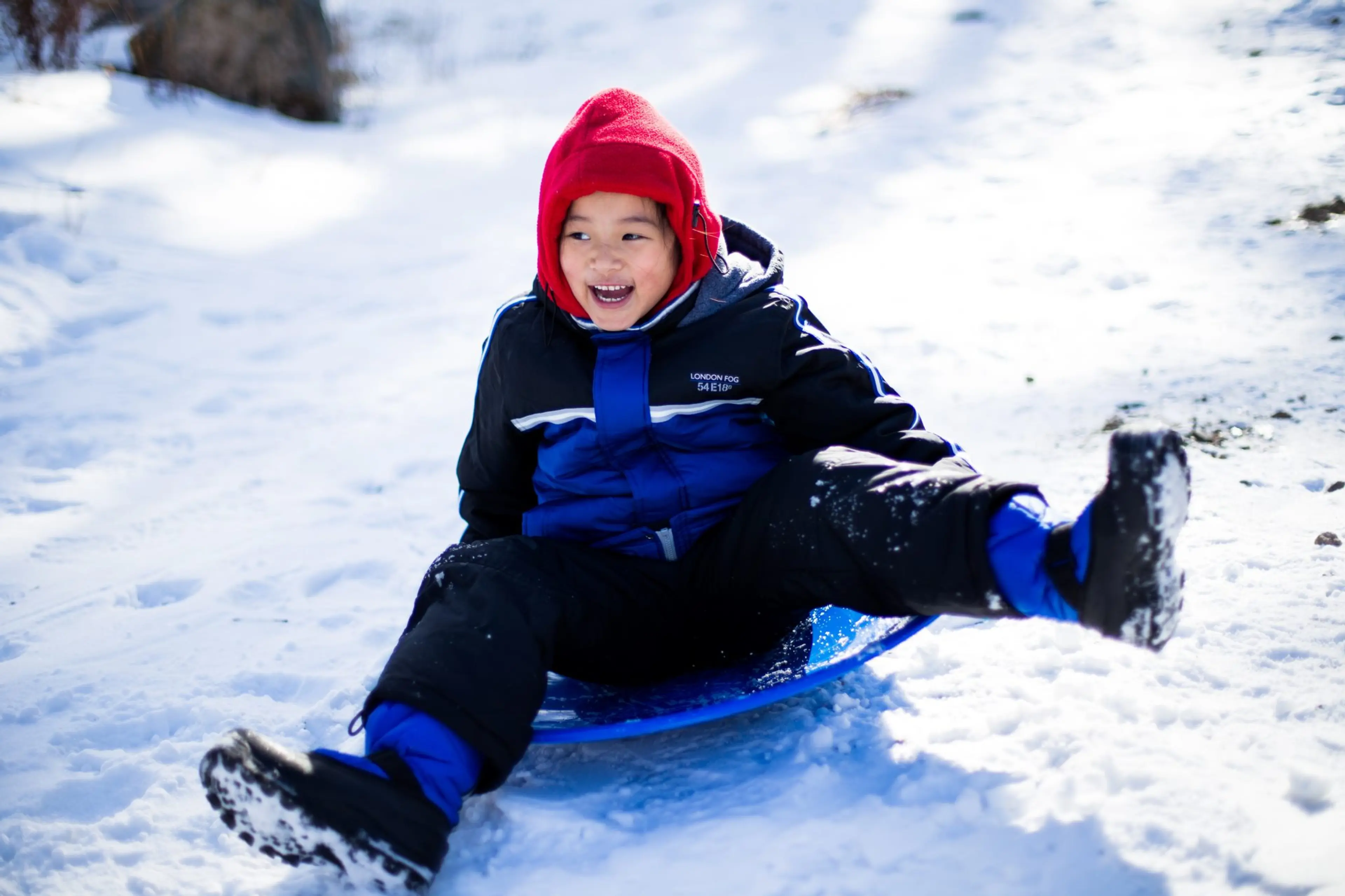 A boy riding a sled in the snow