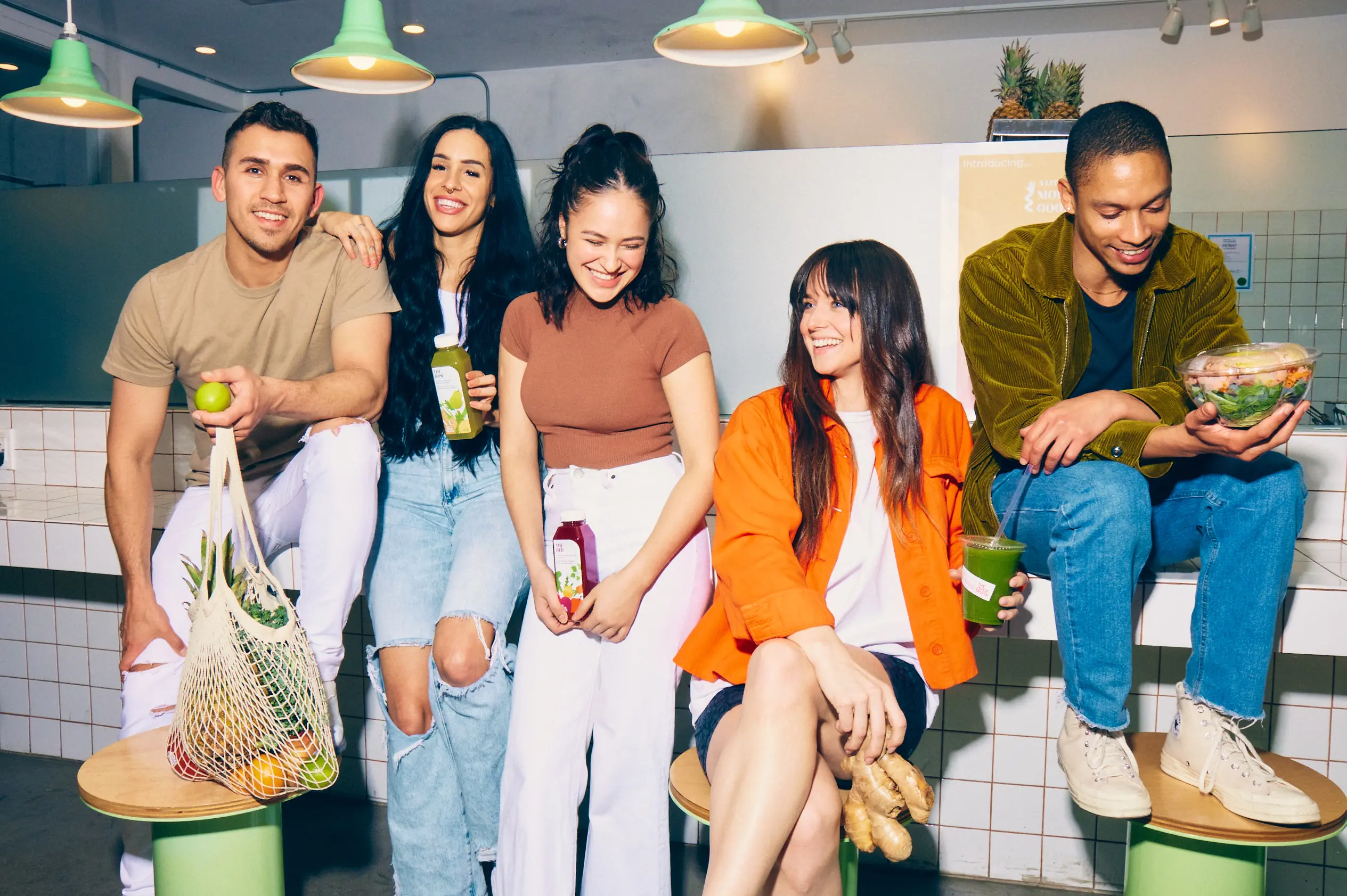 A group of friends post with juices and to-go salads at the Juice Truck in Vancouver