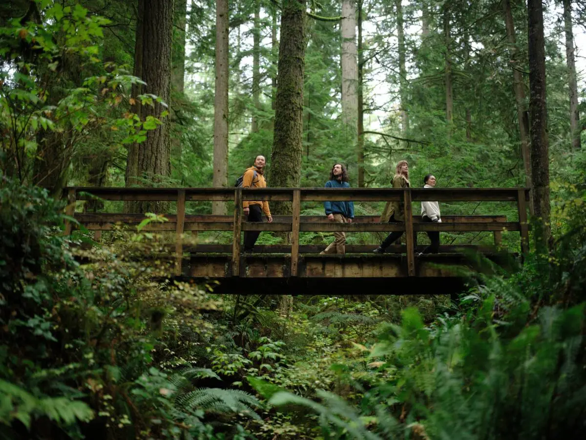 A group of people take a break on a bridge during a hike on Vancouver's North Shore.