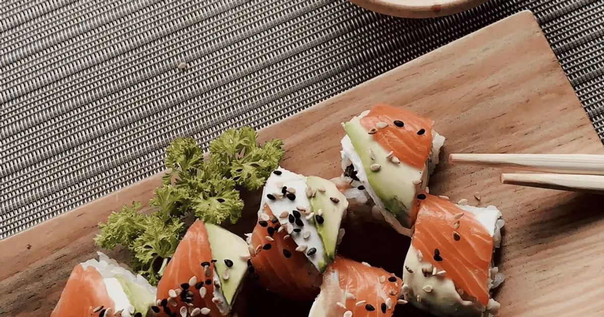 a wooden board with salmon sushi