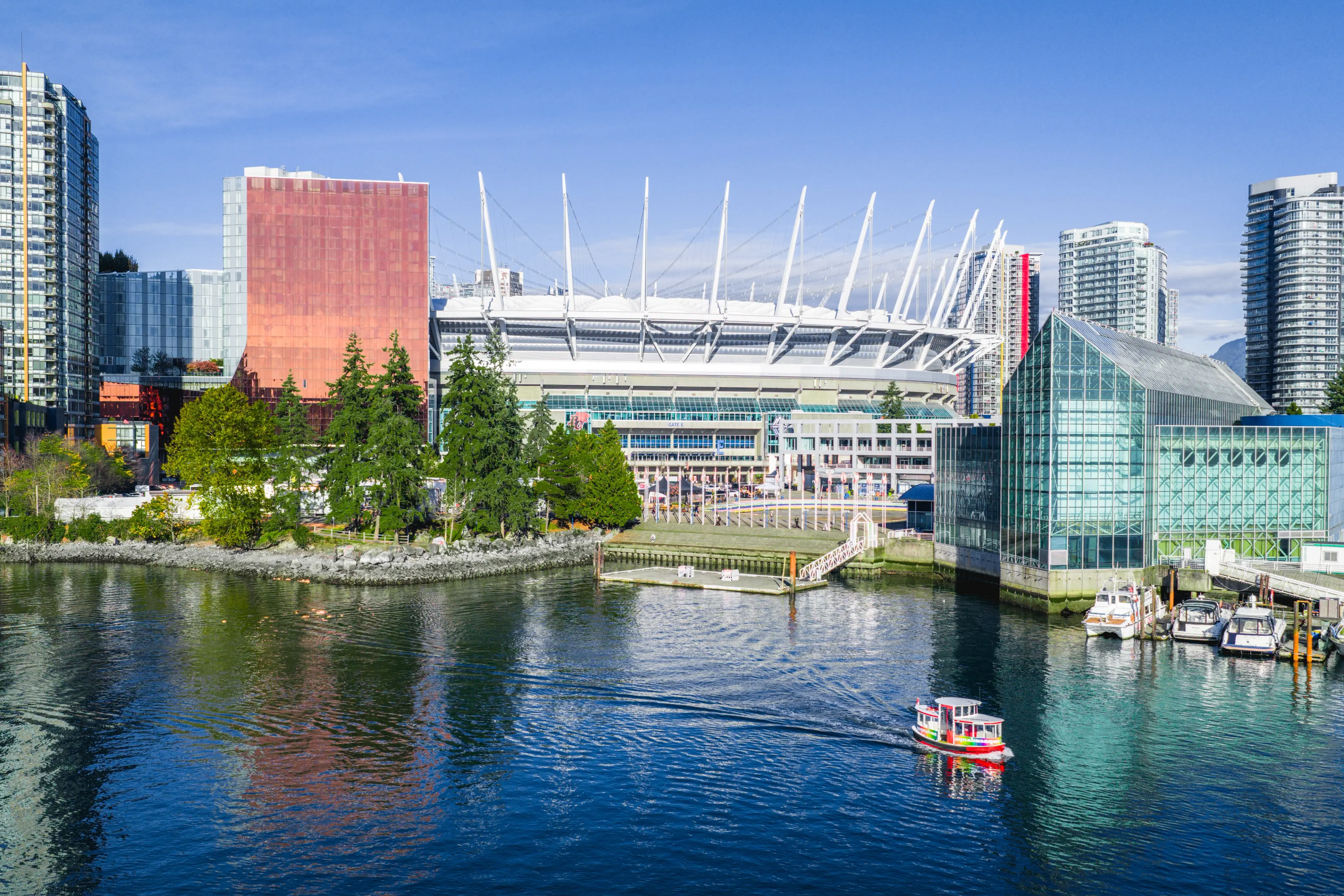 Exterior view of BC Place with the ocean in the foreground.
