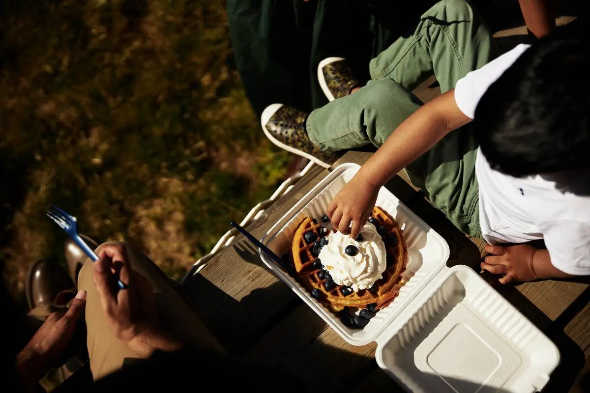 A family enjoying waffles in the sunshine at Krause Berry Farms & Estate Winery