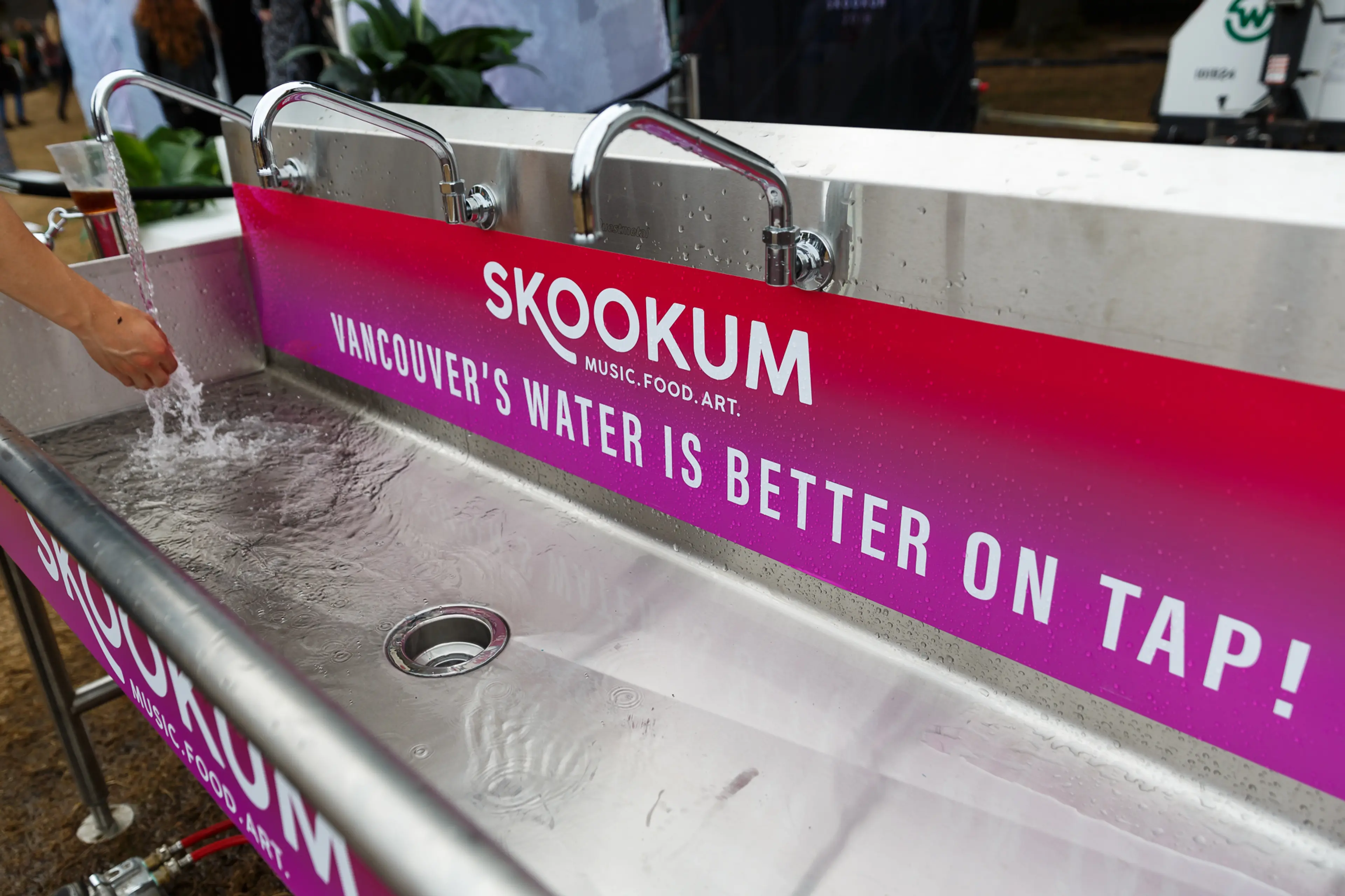 Someone running the tap for a refill water station at SKOOKUM Music Festival