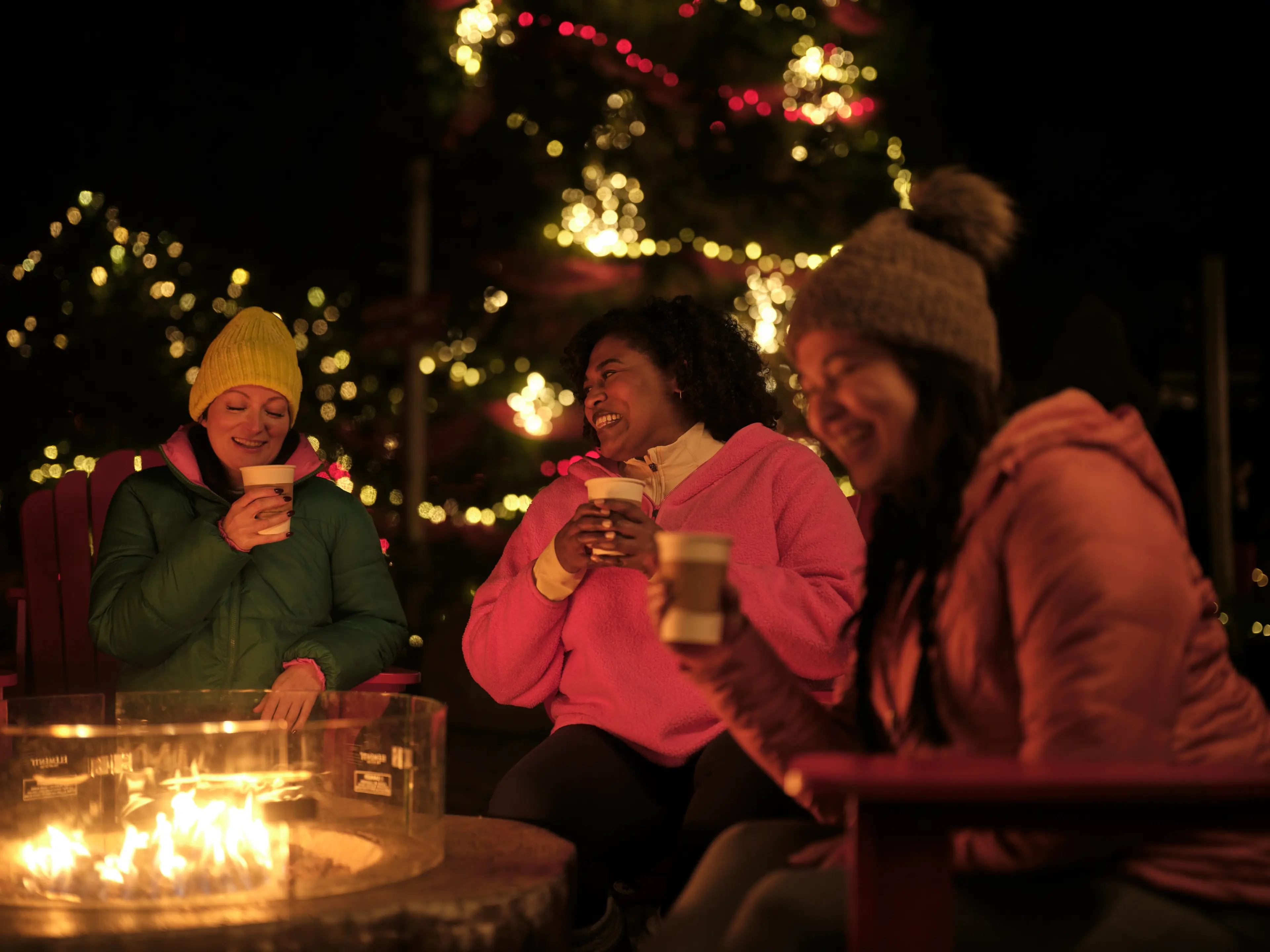 A group of friends enjoying hot chocolate at a fireplace.